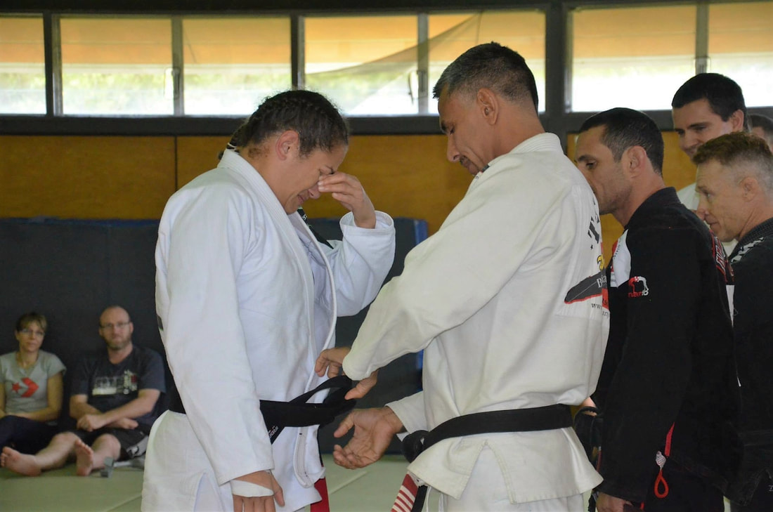 Professor Paulo tying a new black belt