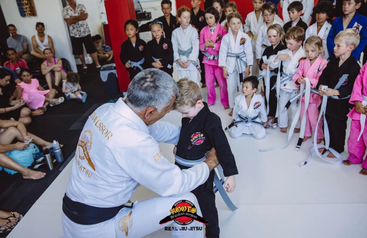 Professor Paulo Guimaraes promoting a young student in front of the class